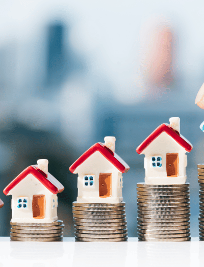 Miniature houses on stacked coins